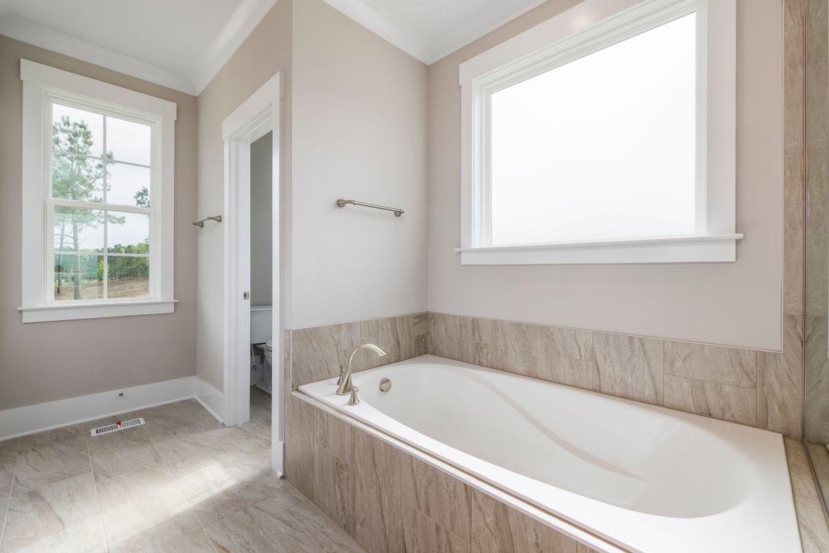 A fitted bathtub beside bathroom tiles