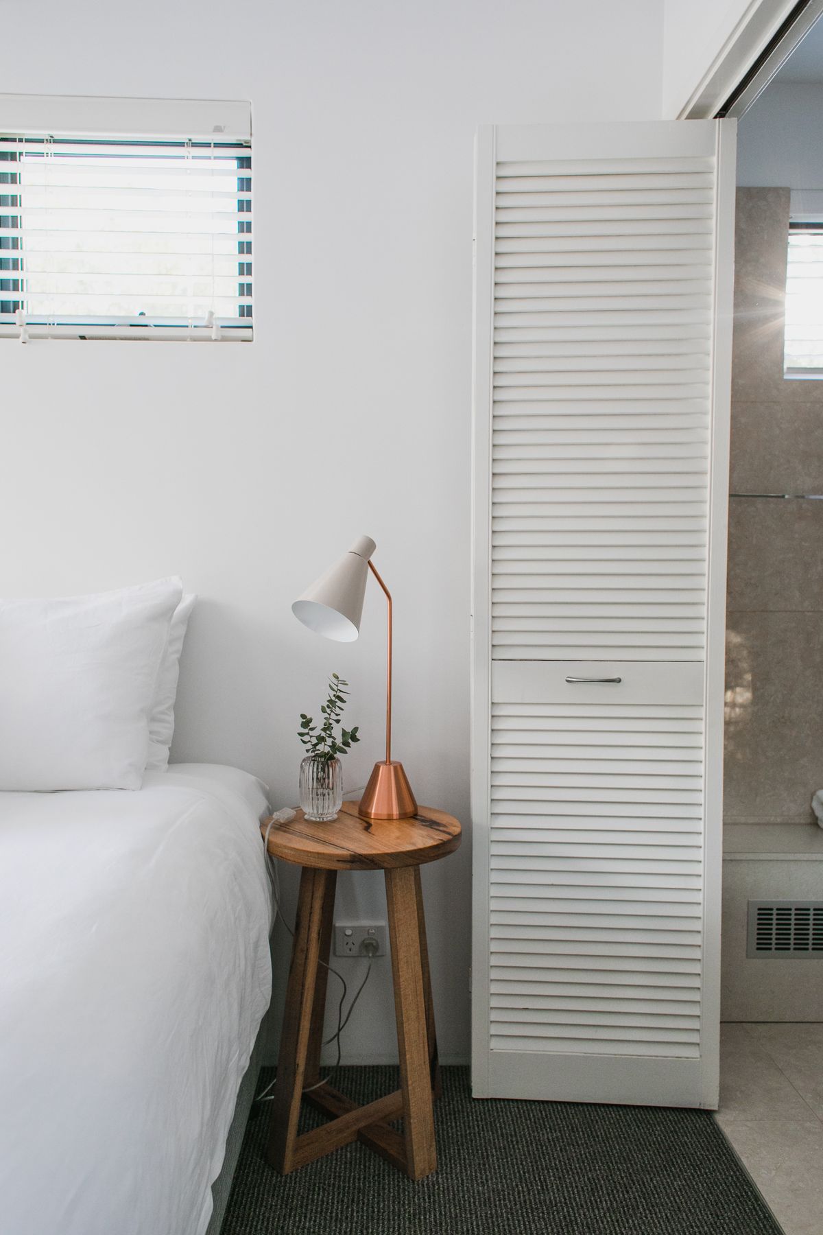 Bedside table with a lamp and flowers