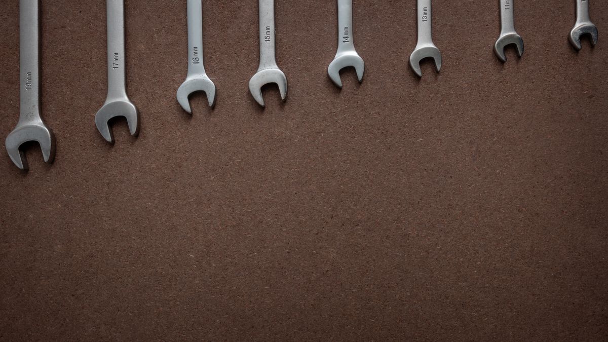 Different sizes of spanner arranged on a wooden board
