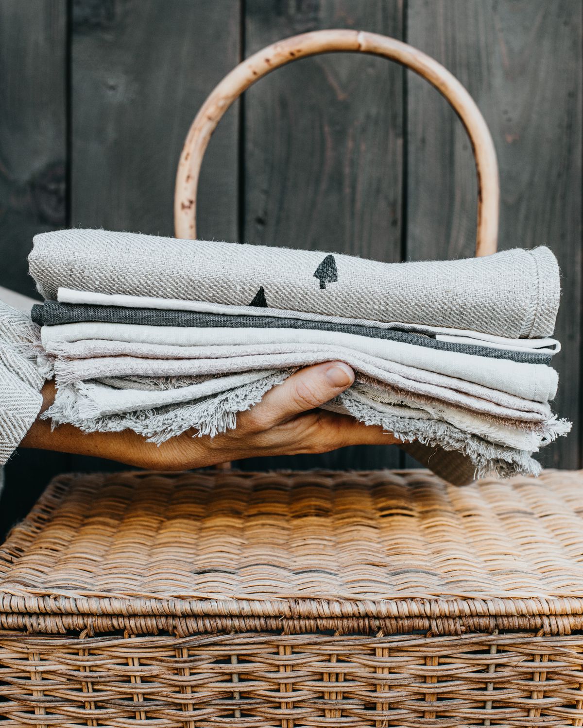 A stack of folded cloths held above a basket
