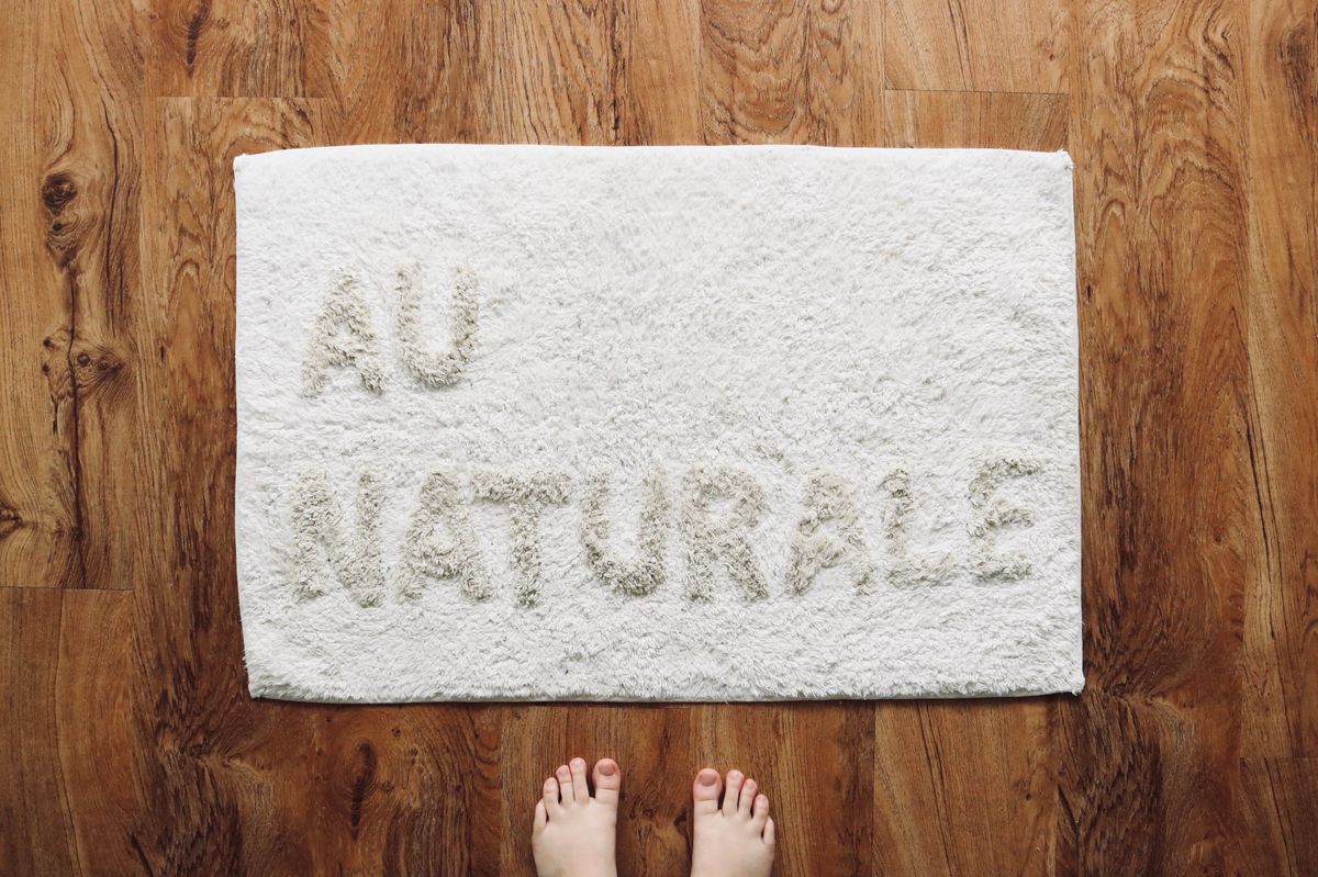 A rectangular fabric doormat on a wooden floor