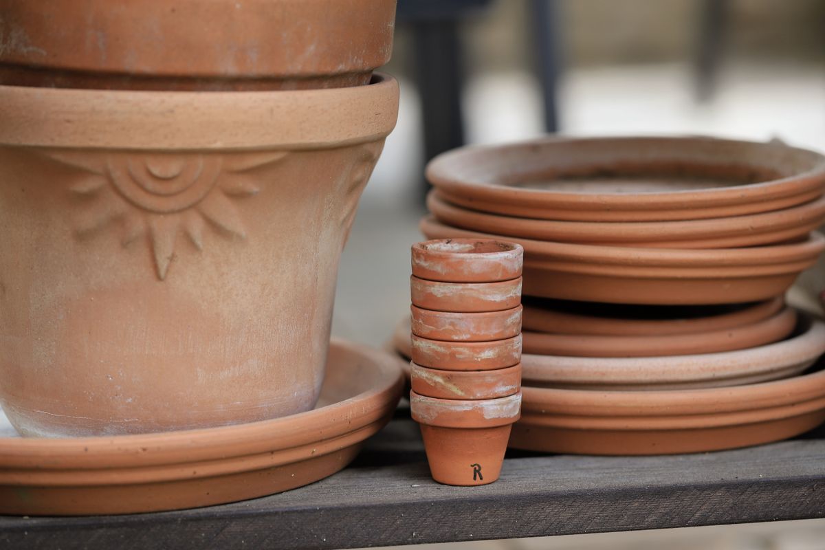 Empty terracotta pots stacked on a shelf