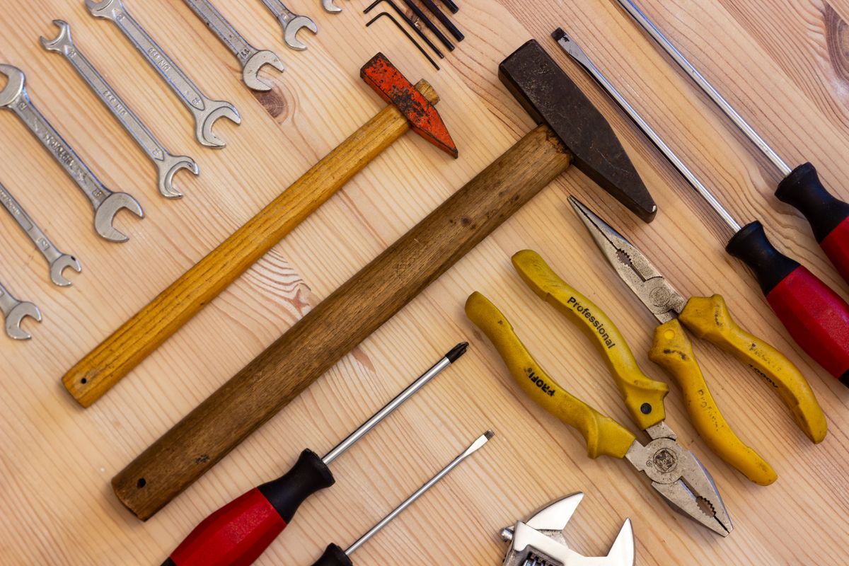 Screwdrivers, spanners and pliers on a wooden surface