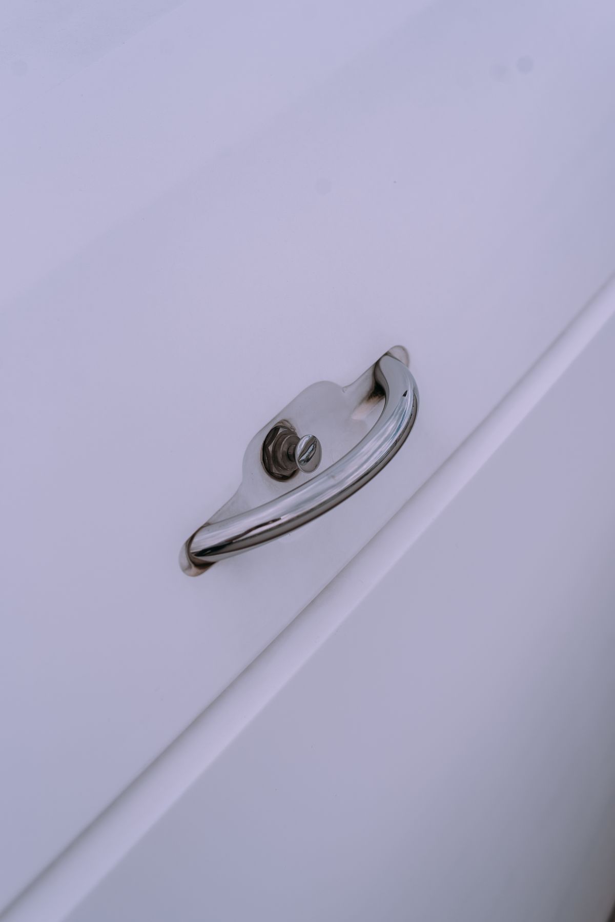 Metal cabinet handle on a white door