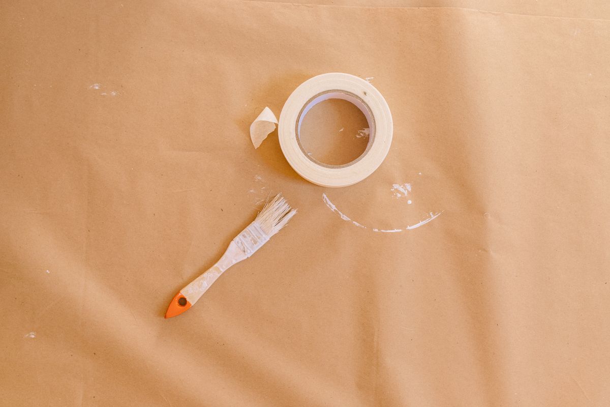 Masking tape and paintbrush on protective paper