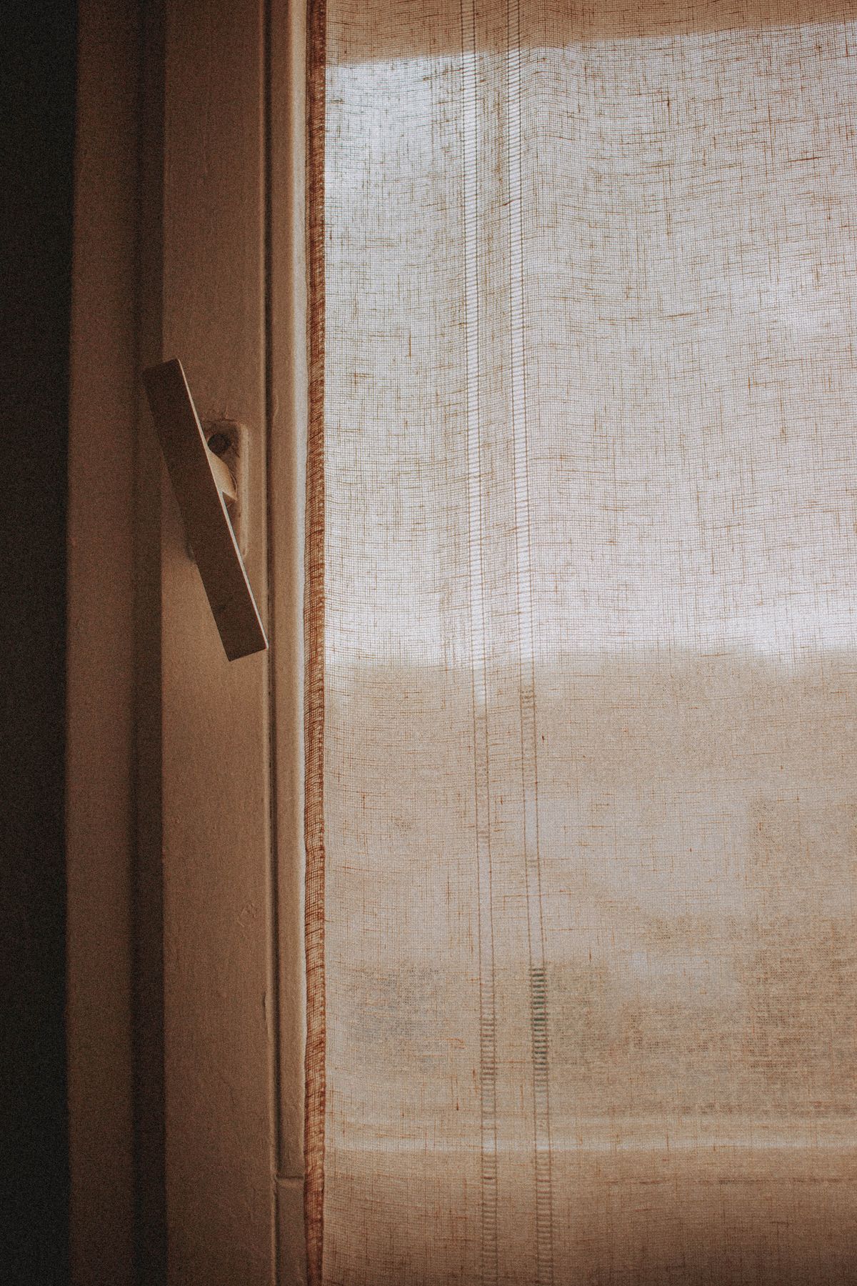 Fabric curtains hanging at an indoor window
